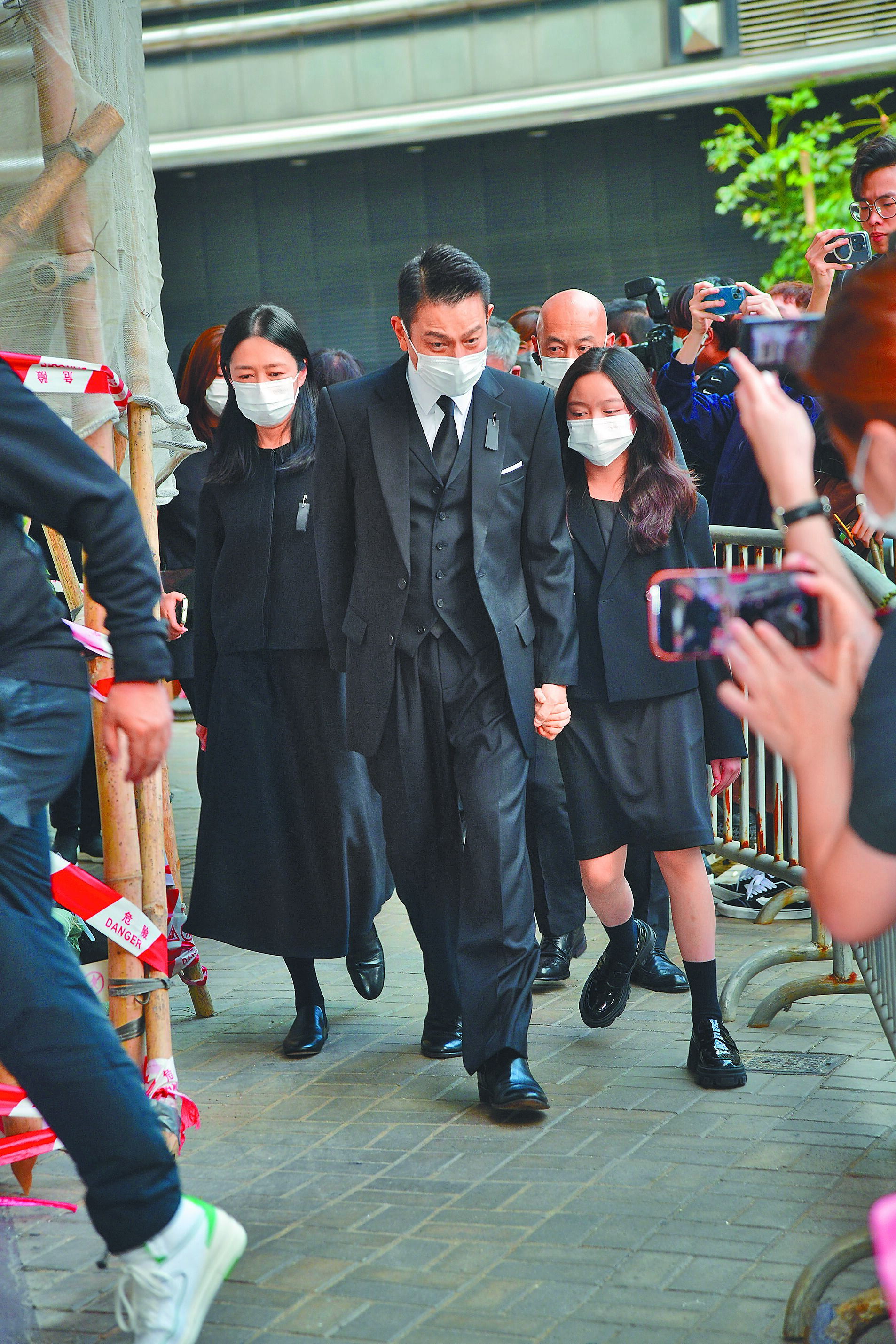 劉德華(中)5日帶著女兒劉向蕙(右)、老婆朱麗倩(左)步入亡父劉禮的靈堂。(明報提供) image