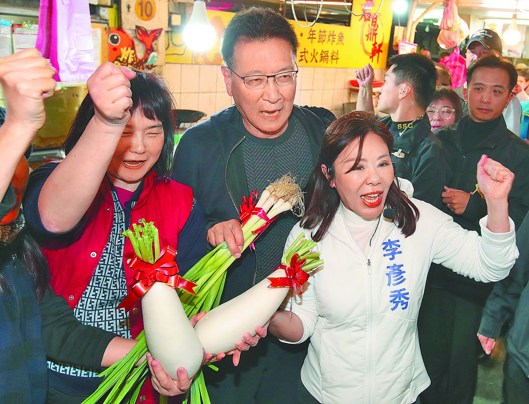 國民黨台北市四選區(內湖、南港)立委候選人李彥秀(前右)7日在國民黨副總統候選人趙少康(左二)陪同下前往市場拜票,舉起民眾贈送的好采頭高喊「凍蒜」。(鄭任南攝) image
