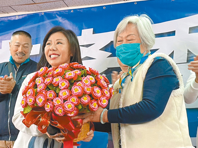 台北市四選區(內湖、南港)立委候選人李彥秀(左二)13日現身競選總部時被支持者包圍,還有人送上花束賀喜。(劉彥宜攝) image