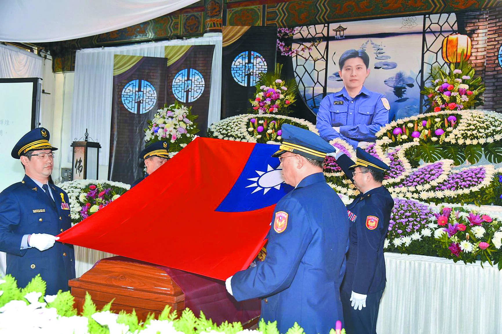 基隆市警局官警為蘇昱鴻的棺槨覆蓋國旗。(基隆市警察局提供/高鈞麟新北傳真) image