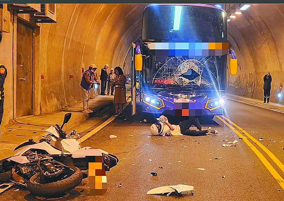 詹姓男子23日騎大型重型機車,替車禍的友人找手機,豈料卻不慎逆向與大型遊覽車發生對撞,他躺在地上仍能滑手機,送醫無生命危險。(警方提供) image