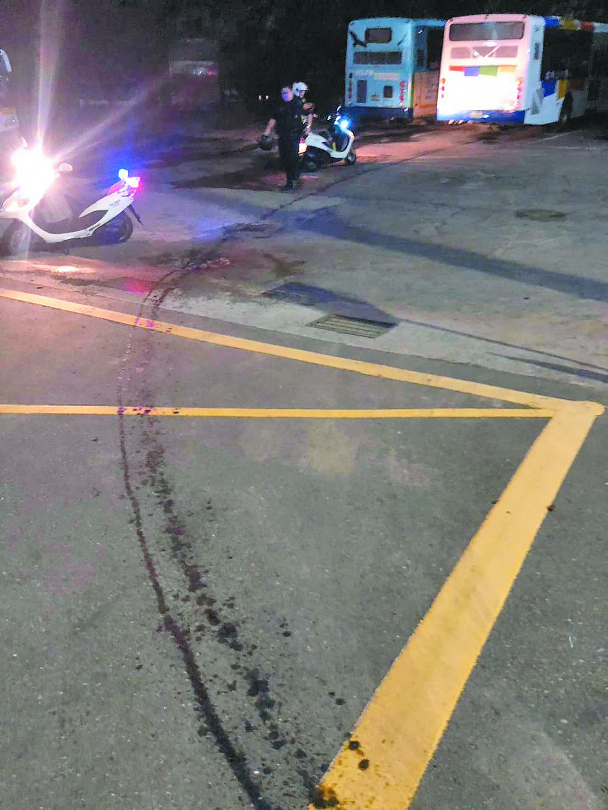 基隆市203路線公車11日晚間車底漏油,造成多名騎士打滑摔車受傷。(基隆市議員施偉政辦公室提供/徐佑昇基隆傳真) image