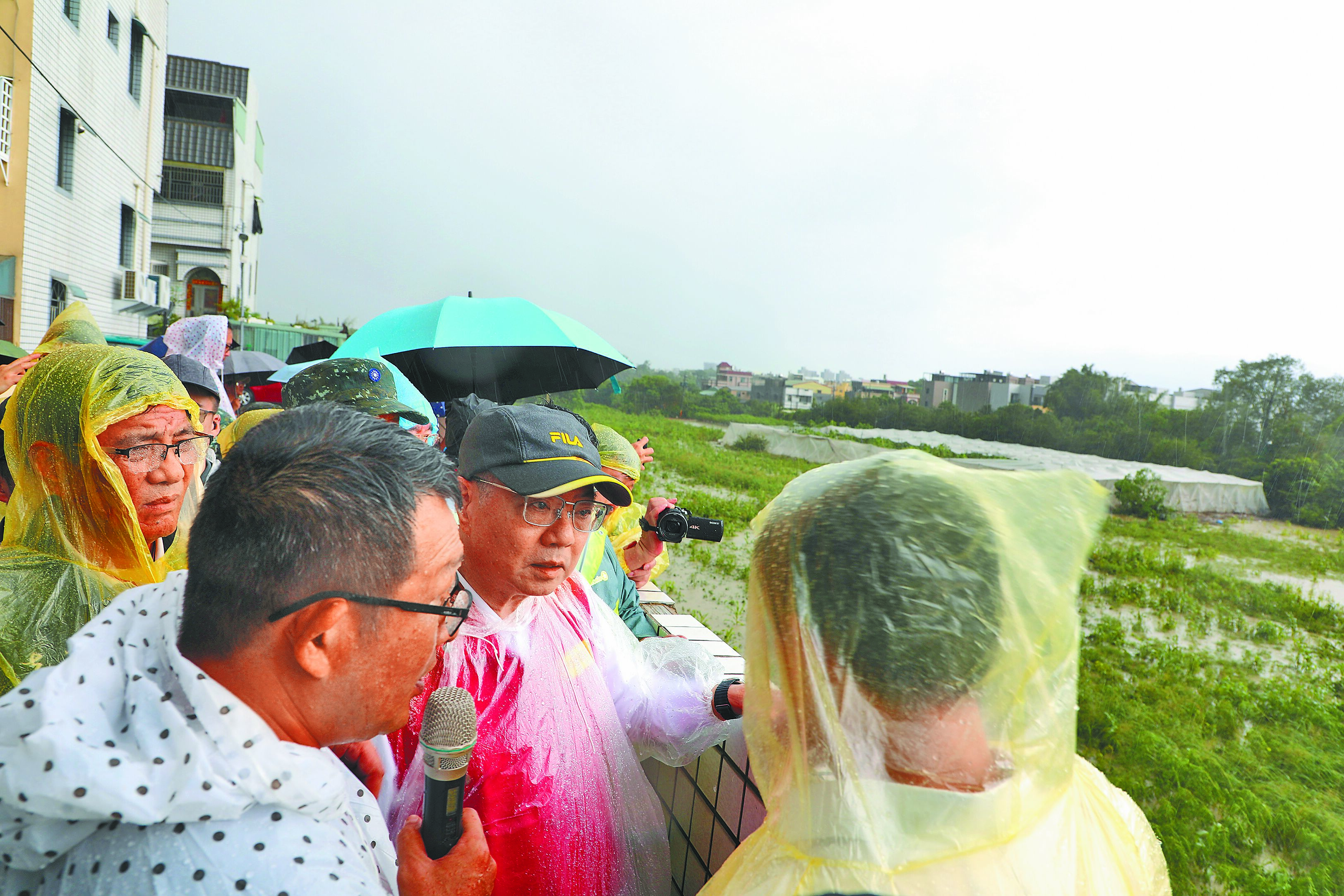 行政院長卓榮泰(戴鴨舌帽者)26日到嘉義縣水上鄉勘察八掌溪畔泡水的木瓜園災損情形。(廖素慧攝) image
