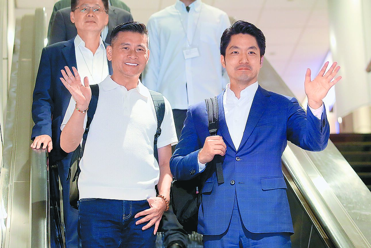 台北市長蔣萬安(右)14日結束訪美行程搭機返台,與同行的台北市議長戴錫欽向媒體揮手致意。(范揚光攝) image
