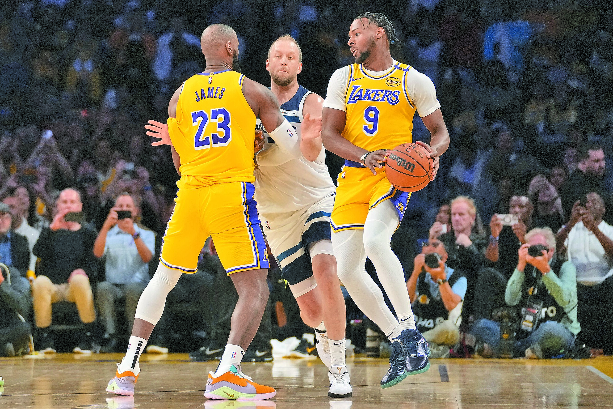 詹姆斯(左)與布朗尼(右)父子檔同隊同場出賽寫下NBA新猷,加上湖人擊敗灰狼,中止開幕戰7連敗,雙喜臨門。(美聯社) image