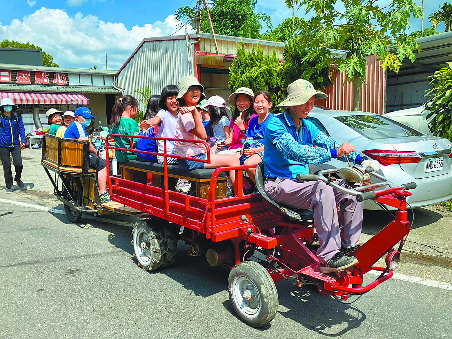 參加大埔社區夏令營的小朋友興奮地搭搬運車下田,開車的是理事長張和賢。(古坑鄉大埔社區提供/周麗蘭雲林傳真) 參加大埔社區夏令營的小朋友興奮地搭搬運車下田,開車的是理事長張和賢。(古坑鄉大埔社區提供/周麗蘭雲林傳真)