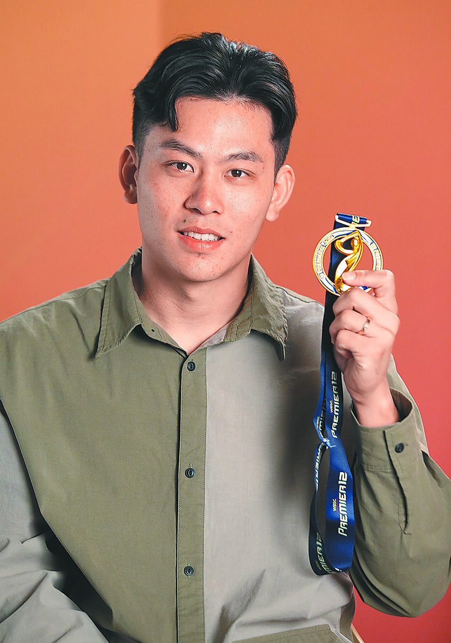戴培峰接受專訪時秀出12強冠軍金牌。(范揚光攝) image