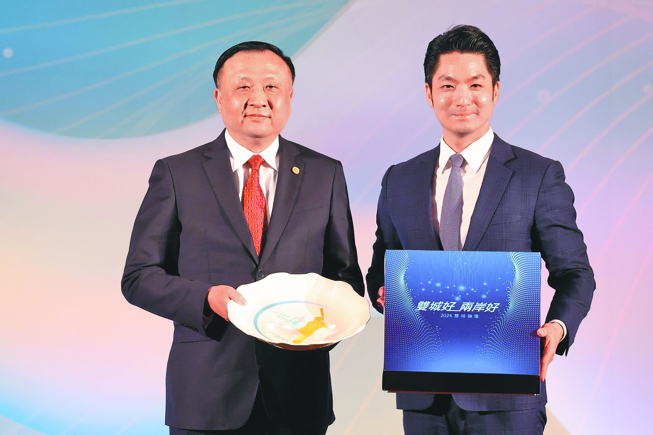 2024年雙城論壇17日於台北揭幕,上海訪問團16日抵台,台北市長蔣萬安(右)、上海副市長華源(左)兩人在台北市政府歡迎晚宴互贈禮物,祝福雙城論壇圓滿成功。(鄧博仁攝) image