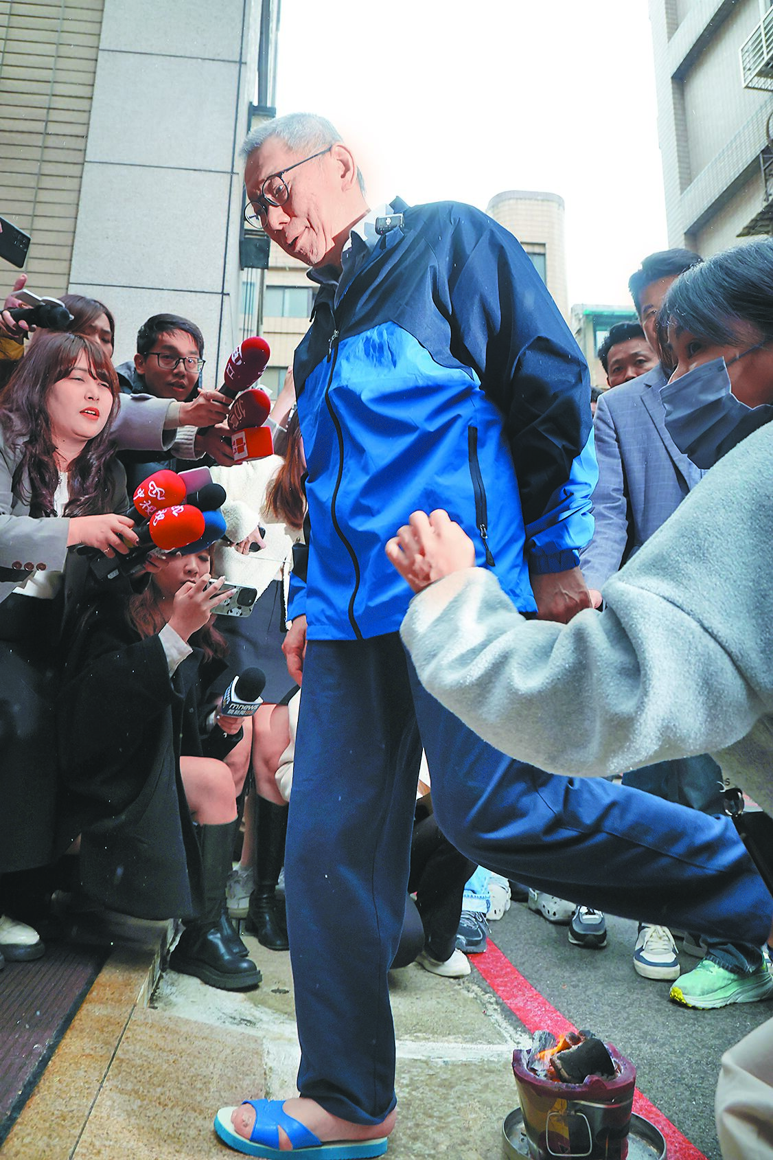 柯文哲交保後,進入家裡前跨火爐去霉運。(鄧博仁攝) image