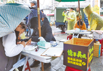 過年連假,26日在北市雙和市場的罷免意向書簽署攤位,仍有民眾冒雨前往。(陳俊吉攝) image