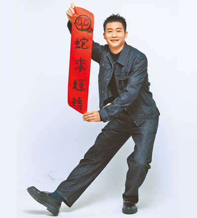 為迎接蛇年,黃冠智接受本報專訪回顧去年成績並親自寫春聯。(郭吉銓攝)服裝提供:agnes b. image