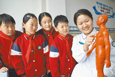 疫後越來越多中醫診所鎖定國際醫療。圖為大陸中醫醫務人員向小學生介紹人體穴位知識。(新華社) image