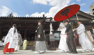 圖為新婚夫婦在東京淺草神社舉行的傳統婚禮儀式上接受護送。(美聯社) image