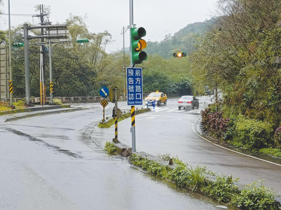 民眾陳情開車行經基隆市七堵區大華二路右彎後馬上就碰到紅綠燈,駕駛常煞車不及衝出停止線,市府在右彎前增設預告號誌提醒用路人減速。(張志康攝) image