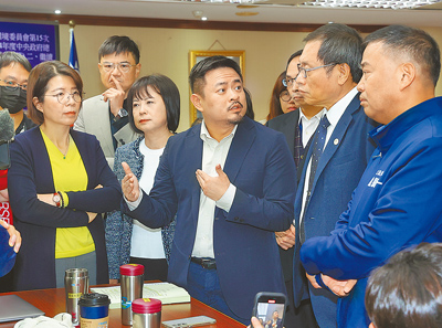 台灣民眾黨11日指出,依審計部報告指出,勞動部5年共濫用就安基金逾7000萬。圖為勞動部長洪申翰(中)與立委溝通。(本報資料照片) image