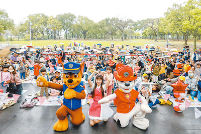 今年台北花伴野餐活動,在雨中於大安森林公園登場。北市府除了規畫5大野餐主題區、質感文青市集、三代同堂戶外攝影棚外,也設置了廣受小朋友喜愛的「汪汪隊」大型充氣玩偶。(台北市觀傳局提供/丁上程台北傳真) image