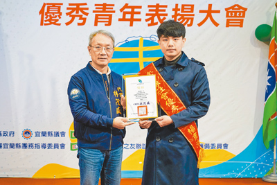宜蘭縣羅東高商國文老師楊肅浩(右)經評選為宜蘭縣優秀青年,20日獲代理縣長林茂盛(左)表揚。(李忠一攝) image