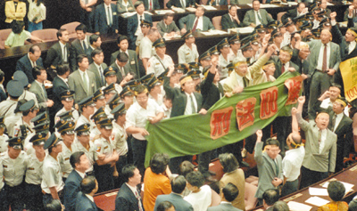 1991年9月民進黨籍立委為了廢除「刑法100條」,在議場拉綠色布條抗議。(本報資料照片) image