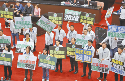 立法院25日院會,民進黨立委霸占主席台杯葛議事,院長韓國瑜宣布休息,國民黨立委拿出標語並高喊「民進黨治國無能,癱瘓國會」。(姚志平攝) image