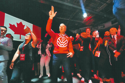 加拿大執政的自由黨29日贏得大選後,總理卡尼(中)在渥太華競選總部隨著樂隊翩翩起舞。 (美聯社) image