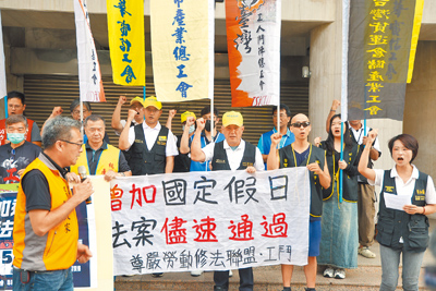 尊嚴勞動修法聯盟與台灣工人鬥陣總工會9日前往立法院舉辦記者會,一同高呼「增加國定假日、法案速通過、別讓勞工再等待」口號。(鄧博仁攝) image