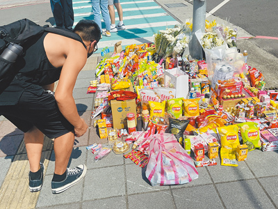 新北市三峽區國成街、國光街口19日下午4時許發生嚴重車禍,釀成3死12傷。民眾20日自發在現場放置鮮花、飲料、零食等追思物品。(李育嫺攝) image