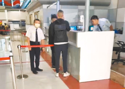 前台南市副市長顏純左的兒子顏大鈞(戴帽者)疑似在保鑣陪同下,準備從高雄小港機場出境時,被查出遭境管未能離境。(民眾提供/郭良傑台南傳真) image