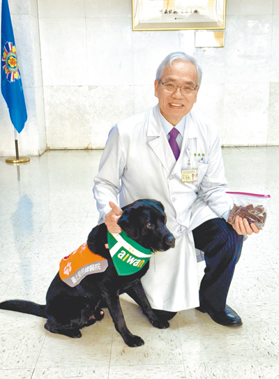 臺北榮民總醫院院長陳威明與安寧病房輔助治療犬「歐巴」。(陳威明提供/林周義台北傳真) image