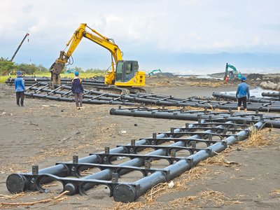 屏東佳冬離岸光電浮台遭丹娜絲颱風吹散,黑色浮台結構體散落南部沿海,旭東公司出動重型機具清除浮台殘骸。(羅琦文攝) image