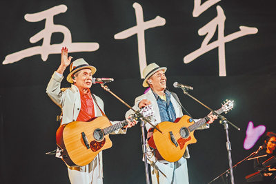 「臺北大巨蛋 民歌大團圓」演唱會宣傳曲〈五十年〉由清清楚楚二重唱吳楚楚(左起)與老搭檔張明智演唱。(中華音樂人交流協會提供) image