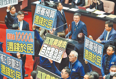 國民黨主席朱立倫喊話,因應關稅4100億特別預算應再增2300億元,並將普發現金納入。圖為國民黨立委在立法院手持「嚴審預算,還錢於民」標語。(本報資料照片) image