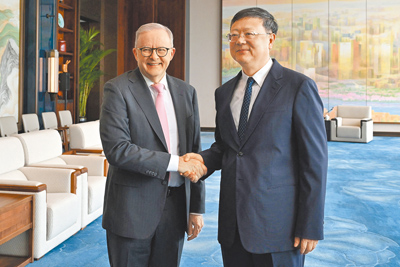 澳洲總理艾班尼斯(左)訪問大陸,13日與上海市委書記陳吉寧握手。(路透) image