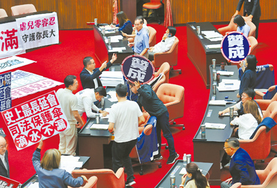 立法院18日院會處理民眾黨所提延會至8月31日,經表決,藍白以人數優勢通過此案,民進黨立委舉牌表達不滿。(姚志平攝) image