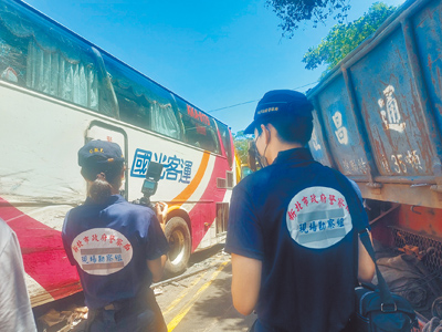 新北市萬里區景美路磚廠公車站牌前23日上午7時許,發生聯結車撞國光客運嚴重車禍,釀1死14傷。圖為新北市刑事鑑識中心派員採證。(張鎧乙攝) image