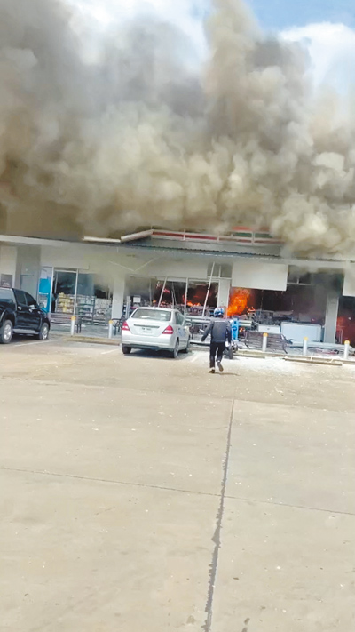 泰國與柬埔寨24日爆發邊境交火衝突,泰國東北部一座加油站遭襲後火勢蔓延至一旁的便利商店,冒出滾滾濃煙。(路透) image
