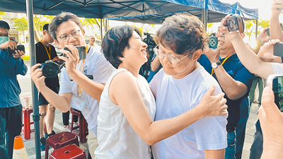 國民黨台東縣立委黃建賓(右)26日反罷免成功,台東縣長饒慶鈴(左)擁抱鼓勵。(蕭嘉蕙攝) image