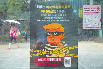 在韓國首爾一個公車站,一張海報將美國總統川普描繪成強盜,以反對川普的關稅政策。海報標語寫著「讓我們向強盜川普發送抗議信」。(美聯社) image