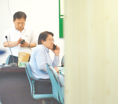大罷免大失敗,林右昌(前)扛責請辭民進黨祕書長,林錫耀(後)回鍋可能性高。圖為兩人不約而同拿手機看資料或接電話 。(本報資料照片) image