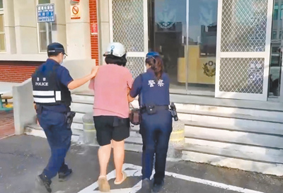 嘉義縣6日驚傳殺夫命案,涉嫌殺死先生的30歲黃女(中)當場被逮捕,帶回派出所製作筆錄。(警方提供/呂妍庭嘉義傳真) image