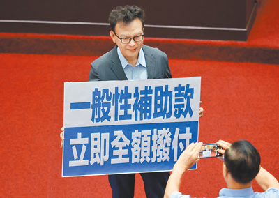 國民黨立委鄭正鈐8日拿著「一般性補助款,立即全額撥付」標語,呼籲行政院立即撥付地方政府一般性補助款。(姚志平攝) image