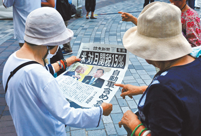 政府第一時間不是學日本向美方爭取豁免關稅疊加,而是把槍口對內,指責提出疑問的人民。圖為7月23日,日本《讀賣新聞》的號外報導美國與日本達成15%的關稅協議。(路透) image