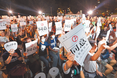 台灣民眾黨22日舉行公投之夜 Taiwan Restart,參與民眾高舉支持重啟核三「同意」的標語。(杜宜諳攝) image