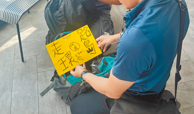 19歲楊姓男子佯稱有演唱會門票詐騙粉絲,用贓款當成徒步環島旅費,警方7月底在台南1家速食店逮到人,楊男身上還帶有「19歲走路環島,求贊助」手板。(讀者提供/洪靖宜高雄傳真) image