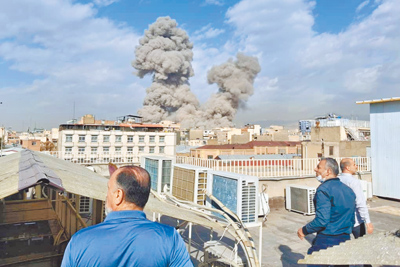 伊朗德黑蘭2月28日遭到空襲後,民眾驚恐看著遠處的濃煙。(美聯社) 伊朗德黑蘭2月28日遭到空襲後,民眾驚恐看著遠處的濃煙。(美聯社)