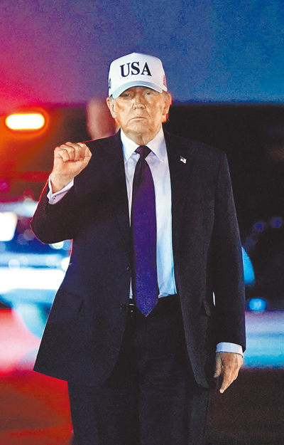 美國總統川普2月27日從「空軍一號」下機時,揮拳致意。(路透) 美國總統川普2月27日從「空軍一號」下機時,揮拳致意。(路透)