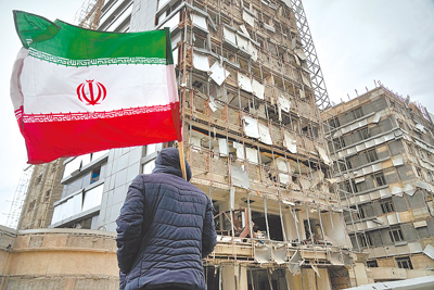 在伊朗德黑蘭,一名男子看著遭受攻擊的甘地醫院外牆。(美聯社) 在伊朗德黑蘭,一名男子看著遭受攻擊的甘地醫院外牆。(美聯社)