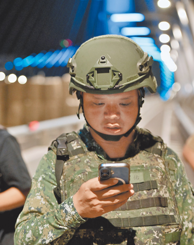 國軍「漢光42號」演習首度納入「行動網路降速」演練,圖為演習現場一名官兵在操演空檔滑動手機嘗試通聯。(郭吉銓攝) 國軍「漢光42號」演習首度納入「行動網路降速」演練,圖為演習現場一名官兵在操演空檔滑動手機嘗試通聯。(郭吉銓攝)