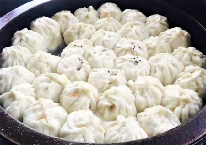 滿滿鐵盤的水煎包一開鍋一上架,撲鼻香氣席捲而來。(陳可文攝) 滿滿鐵盤的水煎包一開鍋一上架,撲鼻香氣席捲而來。(陳可文攝)