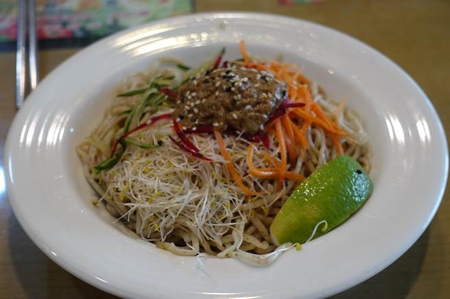 養惠素食的蔬菜涼麵使用全麥麵條搭配新鮮紅蘿蔔絲、小黃瓜絲、甜菜根絲、濃稠芝麻和風醬,最特別的是有一塊新鮮檸檬提味。(周麗蘭攝) image