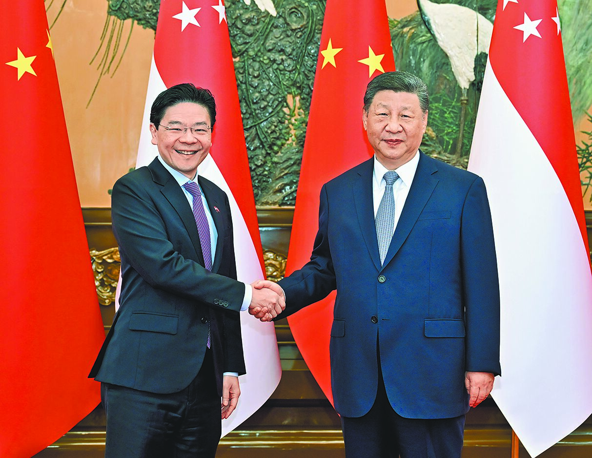 中國國家主席習近平(右)24日在北京人民大會堂會晤新加坡總理黃循財(左)。(新華社) image